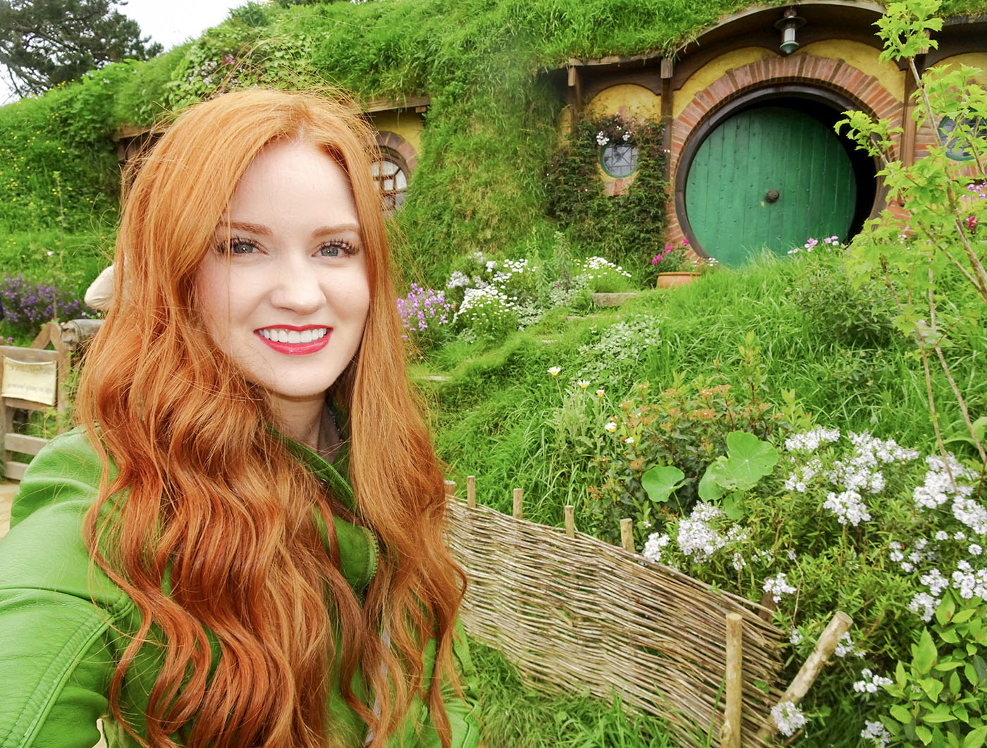 Callie smiling in a vivid green hillside garden with her full face visible