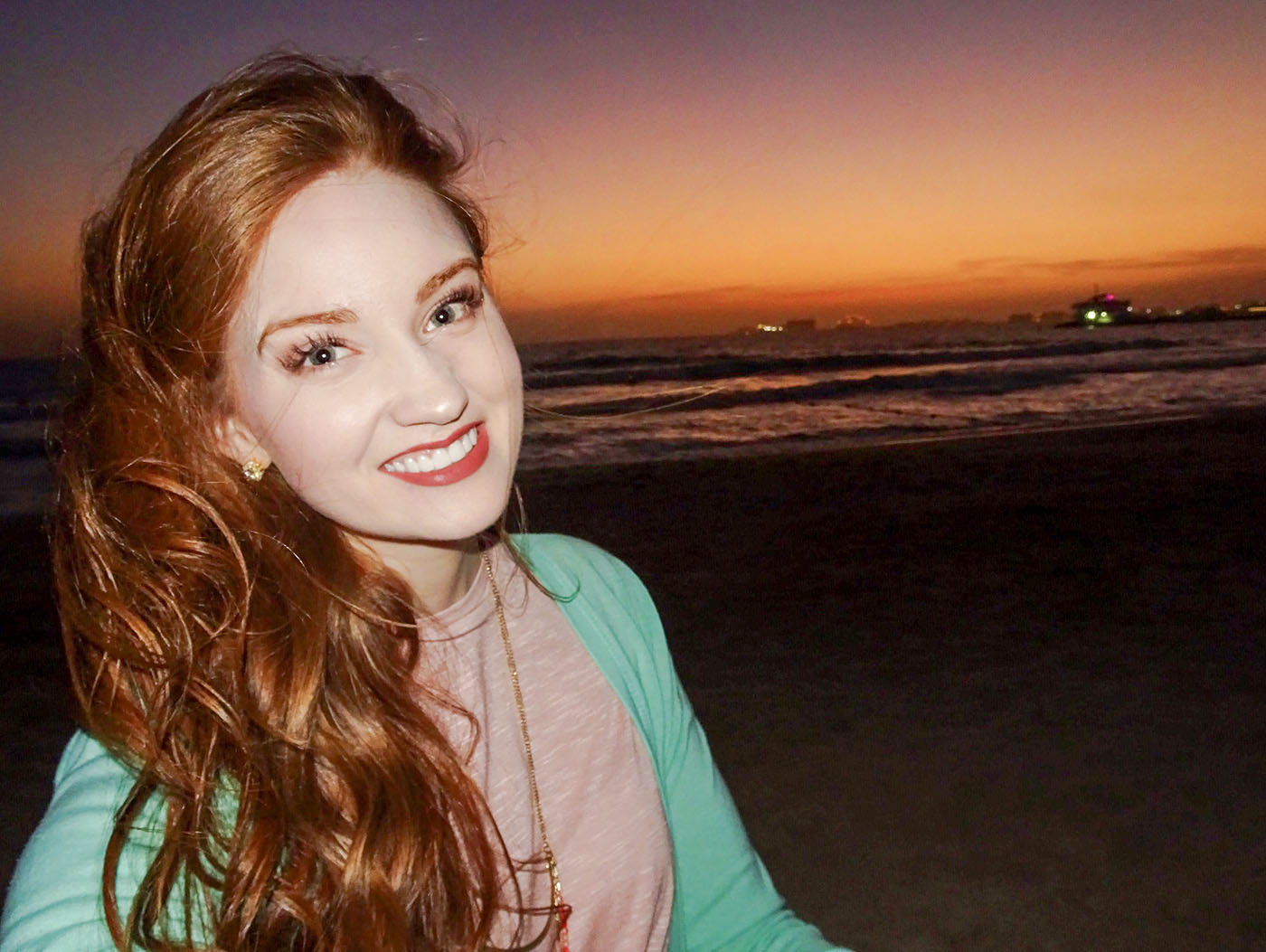 Callie smiling with her full face visible against a glowing sunset