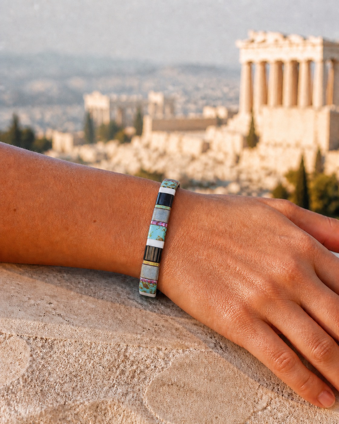 Athens bracelet worn snugly on a wrist above a sunlit stone terrace