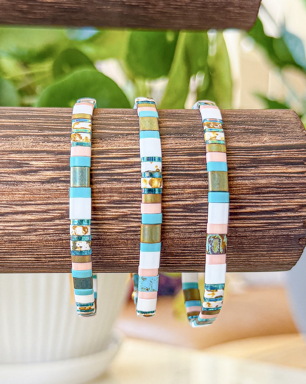 Bracelet close-up photograph in aqua, blush, ivory, and bronze tones