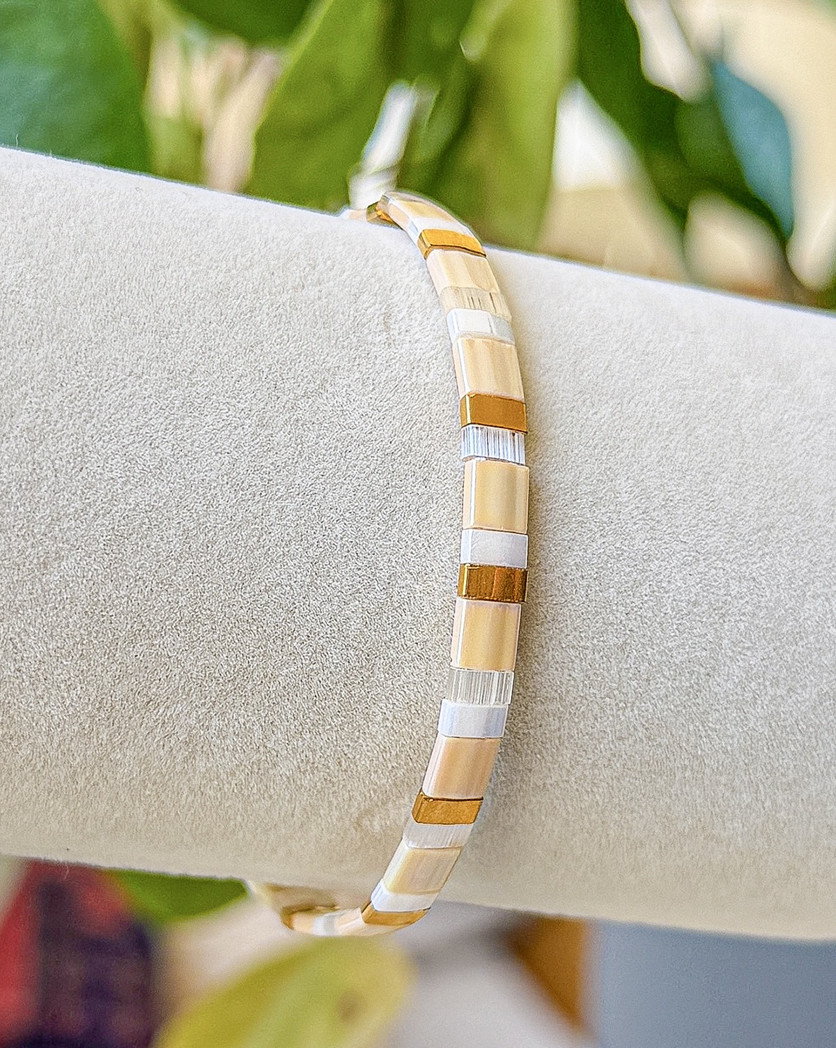 Bracelet close-up photograph in blush, ivory, and olive tones